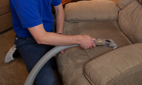 Vacuuming a recliner in a residential living room